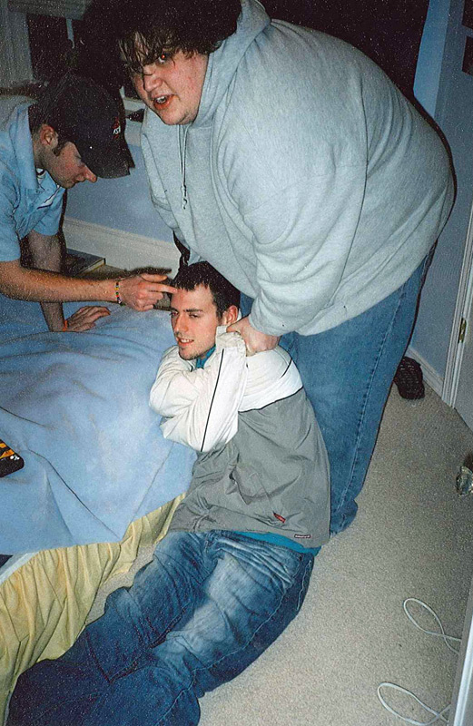 Colin holds down a defenseless Luke while Patrick pokes him.