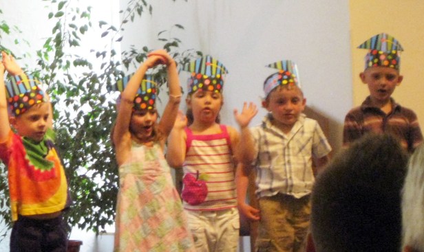 Emerson, middle, performs at her preschool graduation.