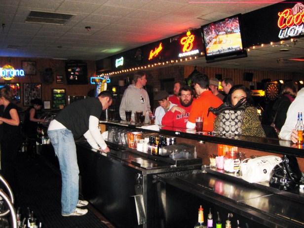 Tending to the large crowd demanding free drinks.