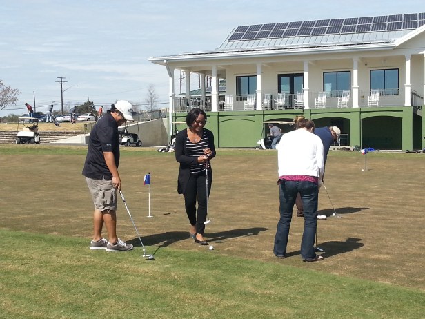 Eddie, Shenea, and Allison practice their putting.