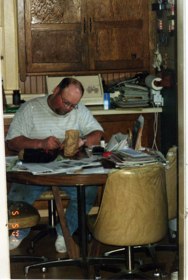 Dad paying bills at the kitchen table.