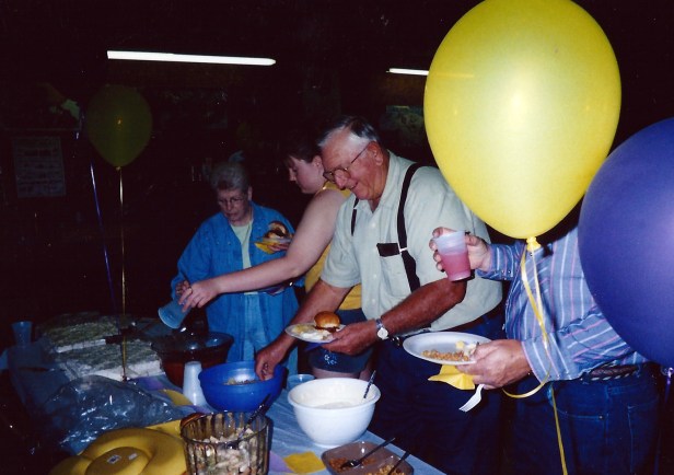 Some random unidentified members of the community eagerly scooping up food to fill their gullets at a celebration.